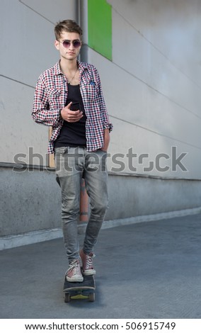 Young man and skateboard on the city street