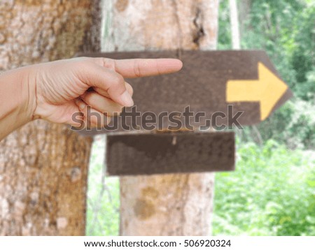  hand pointing to the right with arrow symbol blurred background,concept the route.       