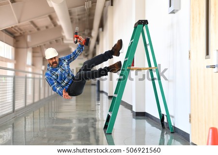 Construction worker falling off the ladder inside a building Royalty-Free Stock Photo #506921560