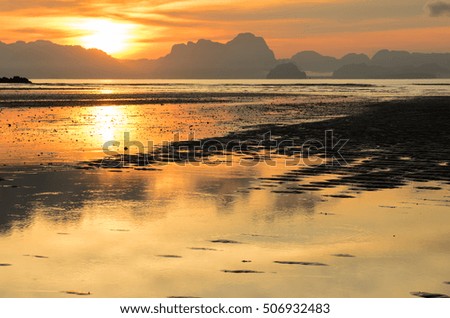 Low tide at tropical beach with vibrant sunrise sky background, Yao Noi Island, Thailand