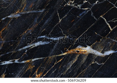 Gold, yellow and white patterned detailed of dark gray marble texture background.