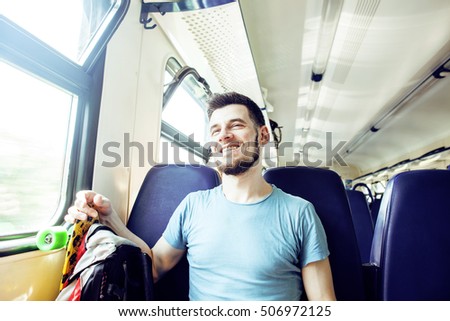 young pretty modern hipster guy traveller on train with skateboard alone, lifestyle vacation people concept