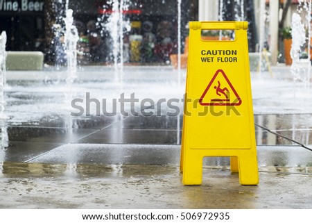 Wet floor sign at outdoor fountain of department store