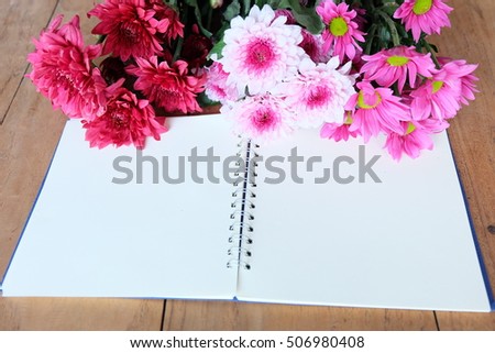 mum flowers with notebook on wooden, in valentine's day