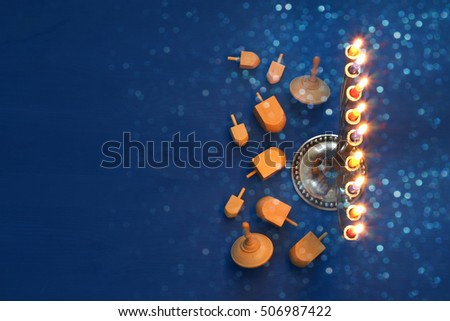 Top view Image of jewish holiday Hanukkah with menorah (traditional Candelabra) and wooden dreidel (spinning top). Selective focus