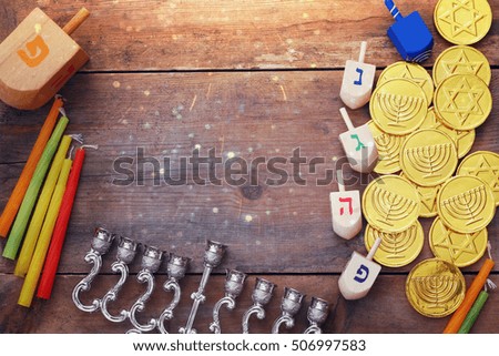 Top view Image of jewish holiday Hanukkah with wooden dreidels colection (spinning top), coins chocolate and menorah (traditional Candelabra) on the table