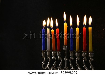 Low key Image of jewish holiday Hanukkah background with menorah (traditional candelabra) and burning candles