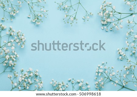 Wedding flower frame on blue background from above. Beautiful floral pattern. Flat lay style.