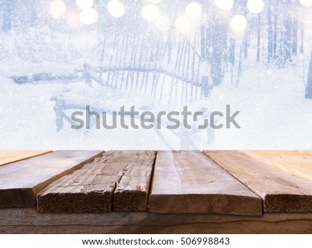 Empty wooden table in front of dreamy and magical winter landscape background. For product display montage