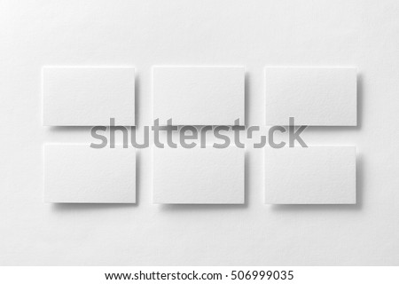 Mockup of white business cards arranged in rows at white design paper background.
