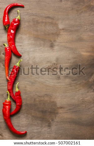 Group of red chili peppers on a brown wooden background