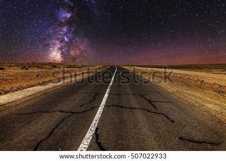Cracked desert road under the magnificent starry sky 
