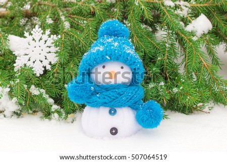 Snowman in a knitted hat and fir branches. Christmas decorations.
