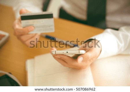 Selective focus man holding smart phone and credit card. Shopping Online. Vintage or pastel effected photo.