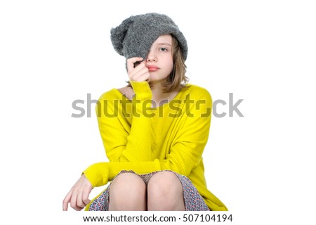 Portrait of a cute teen girl, who pulls his cap over her face.
