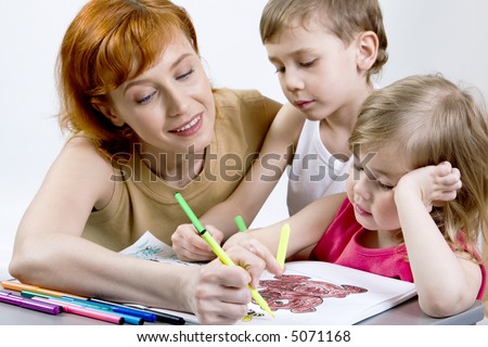 Pretty mother, her smart son and daughter are drawing the picture together