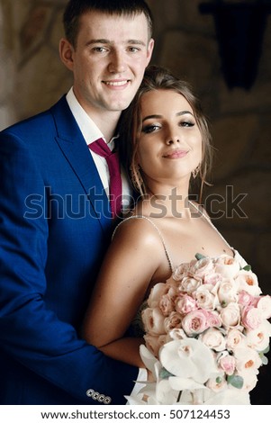 Portrait of stunning newlyweds leaning to each other
