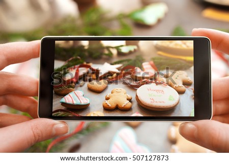 Christmas traditional treat photography on phone. Taking a picture of gingerbread cookies variety. Food photography, Instagram, culinary concept