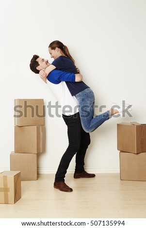Excited couple embracing and moving house