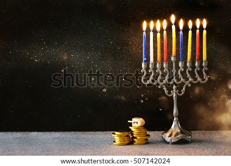 low key image of jewish holiday Hanukkah with menorah (traditional Candelabra) and wooden dreidels (spinning top)

