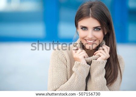 Beautiful woman in a sweater in the fall. Outdoor lifestyle close up portrait of happy brunette young woman in stylish casual outfit.  
