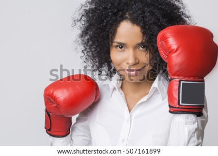 Close up of African American woman's head with her boxing gloves in the air. Concept of business competition
