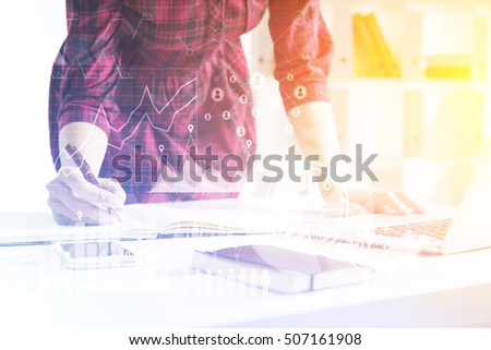 Standing girl taking notes and leaning at table. Concept of engineer's work. Toned image. Graphs and world map on the foreground. Toned image. Elements of this image furnished by NASA