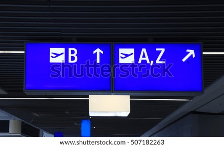 Info sign at international airport with directions for check in and boarding gates