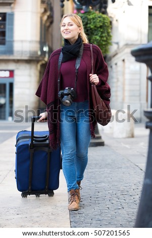 Cheerful and inquisitive young woman taking a journey in the city