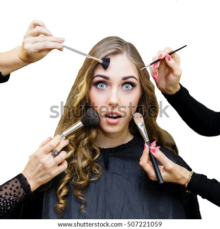 Portrait of young beautiful woman with long curly blonde hair in beauty salon. Four hands holding a make-up brushes. Conceptual photo. Isolated on white background.