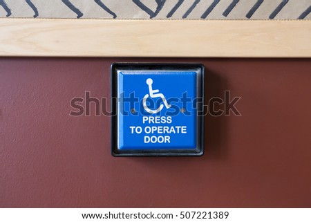 Handicapped access entrance pad mounted to a wall.