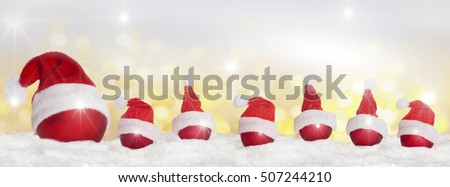 Many Christmas tree balls with Christmas hat in the snow