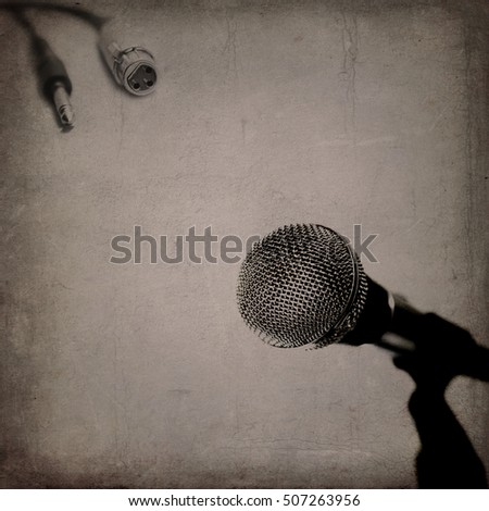 Grunge music background with vintage dynamic microphone and cables