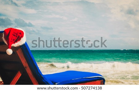 chair lounge with red Santa hats on tropical beach