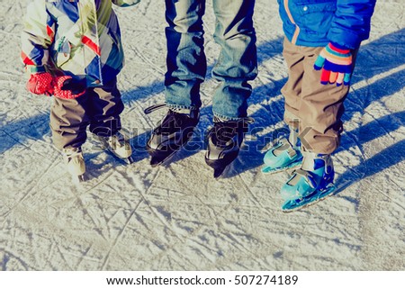 father with two kids skating in winter