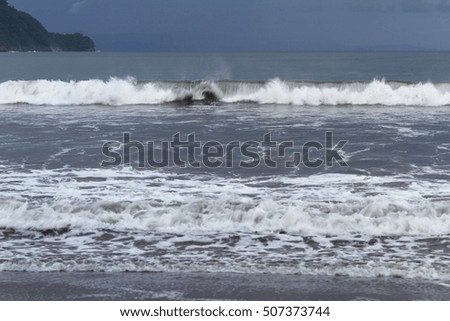 slow shutter speed on a tight shot of waves coming in crashing with a bit of blur for a motion effect