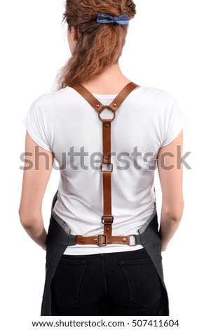 Young redhaired woman chef or waiter posing, wearing apron and t-shirt isolated on white background.
