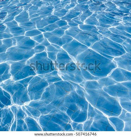 Surface of swimming pool water background,Blue pool water with sun reflections,Background of rippled pattern of clean water in blue swimming pool