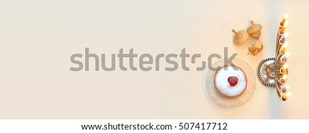 Top view Image of jewish holiday Hanukkah with menorah (traditional Candelabra) and wooden dreidel (spinning top). Selective focus