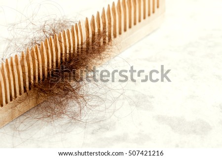 Hair on wooden comb close up - hair loss problem concept Royalty-Free Stock Photo #507421216