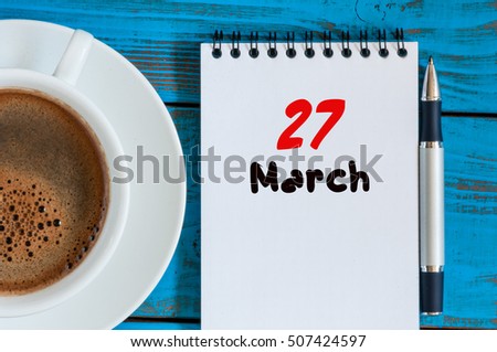 March 27th. Day 27 of month, calendar on blue wooden table background with morning coffee cup. Spring time, Top view. World Theatre Days