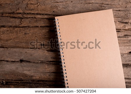 brown note book on wood table