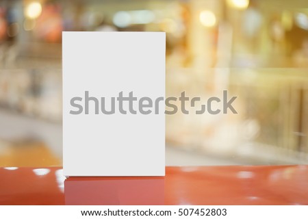 Mock up Menu frame  in Bar restaurant ,Stand for booklets with white sheets of paper acrylic tent card on wooden table on