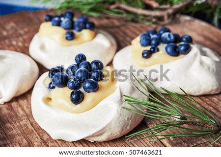 meringue nests topped with lemon curd and blueberry
