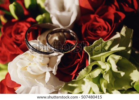 beautiful bouquet of red roses with wedding rings