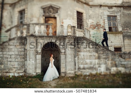 wonderful young bride standing on a background of gray walls of the castle