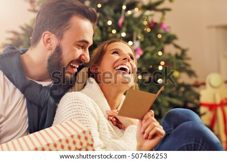 Picture showing young couple with present over Christmas tree