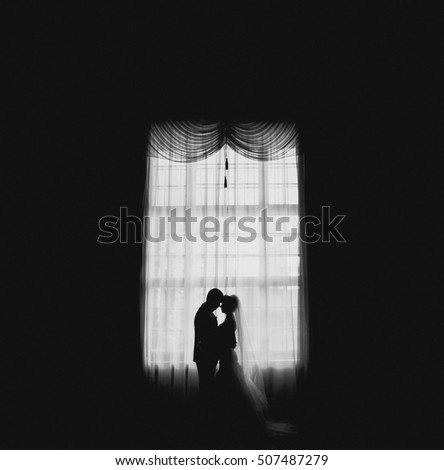 young couple kissing on the background of window
