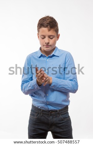 Emotional boy brunette in a blue shirt on a white background