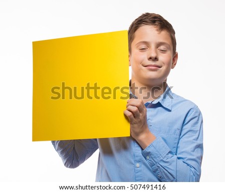 Emotional boy brunette in a blue shirt with yellow sheet of paper for notes on a white background